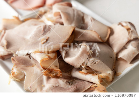 Thinly sliced sausage, ham on a white plate 116970097