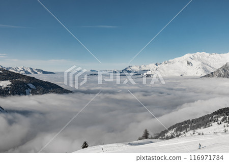 Mountains towering above serene cloud blanket 116971784