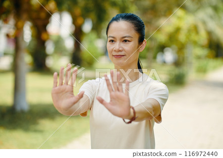 Practicing Tai Chi in a Sunny Park Setting Practicing Tai Chi in a Sunny Park Setting 116972440