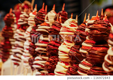 Chocolate coated fresh strawberry skewers at fruit stall at famous Barcelona food market La Boqueria 116972843