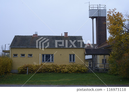yellow single-story building with a tile roof and small, rectangular windows yellow single-story building with a tile roof and small, rectangular windows 116973118