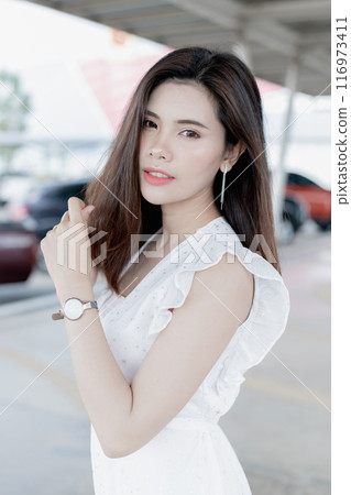 Asian woman in casual work clothes Posing in the parking lot. 116973411