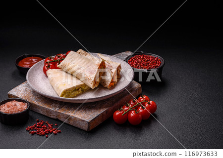 Delicious juicy roll or shawarma with chicken, tomatoes, salad and sauce 116973633