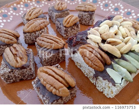 Mexican amaranth sweets served on a baking tray (walnuts, pumpkin seeds, peanuts, chocolate, etc.) 116973753