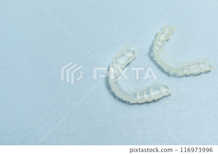 Top View Dirty Teeth Dental Night Guards in Box, White Pink Container. Blue Background. Copy Space For Text. Mockup Clear Retainer. Oral Hygiene, Cleaner. Horizontal Plane. 116973996