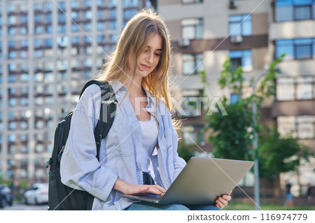 Young female college student using laptop computer outdoor 116974779