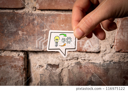 IDEA and SKILL Concept. Speech bubble in hand on red brick background 116975122