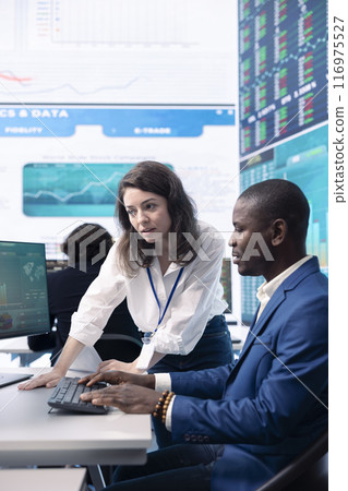 Enterprise colleagues reviewing project updates and details in monitoring room, establishing budget and other resources to achieve strategic business goals. Multiple corporation operations. Enterprise colleagues reviewing project updates and details in monitoring room, establishing budget and other resources to achieve strategic business goals. Multiple corporation operations. 116975527