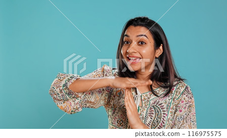 Portrait of assertive indian woman asking for timeout, doing hand gestures, feeling fatigued. Firm person doing vehement pause sign gesturing, wishing for break, studio background, camera B Portrait of assertive indian woman asking for timeout, doing hand gestures, feeling fatigued. Firm person doing vehement pause sign gesturing, wishing for break, studio background, camera B 116975575