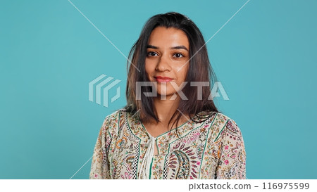 Portrait of cheerful friendly indian woman smiling, looking pleased, isolated over studio background. Happy person in traditional attire having positive facial expression, feeling satisfied, camera B Portrait of cheerful friendly indian woman smiling, looking pleased, isolated over studio background. Happy person in traditional attire having positive facial expression, feeling satisfied, camera B 116975599