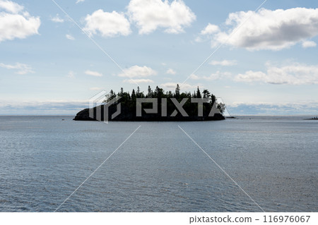 A gorgeous view of an island covered with rocks and trees on Lake Superior. 116976067