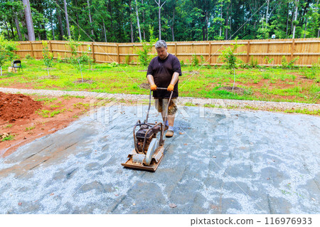 Sand is compacted by vibratory tamping machine during construction of pool platform Sand is compacted by vibratory tamping machine during construction of pool platform 116976933