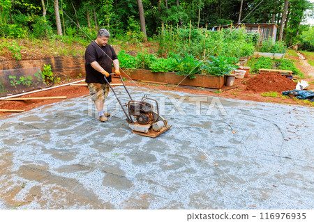 Compaction sand using vibratory tamping machine during construction of pool platform Compaction sand using vibratory tamping machine during construction of pool platform 116976935