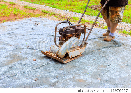 Compaction of sand by vibratory tamping machine during construction of pool platform 116976937