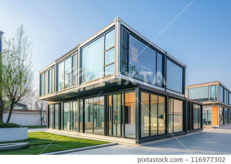 A large, modern house with a lot of glass windows and a balcony 116977302