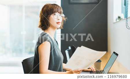 Smiling Japanese businesswoman doing desk work Smiling Japanese businesswoman doing desk work 116979680