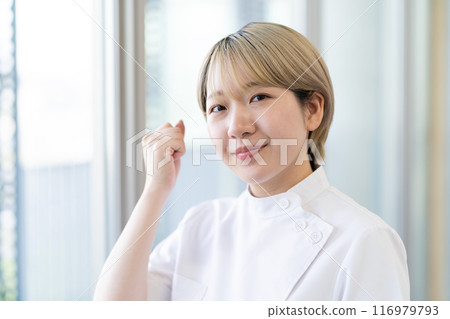 Casey 一位年輕的女性脊椎按摩師，金髮短髮，穿著白色外套（頭髮顏色自由，按自己的方式工作，工作環境） 116979793