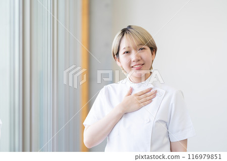 A young female chiropractor with short blonde hair wearing a Casey white coat (free hair color, work in your own way, work environment) A young female chiropractor with short blonde hair wearing a Casey white coat (free hair color, work in your own way, work environment) 116979851