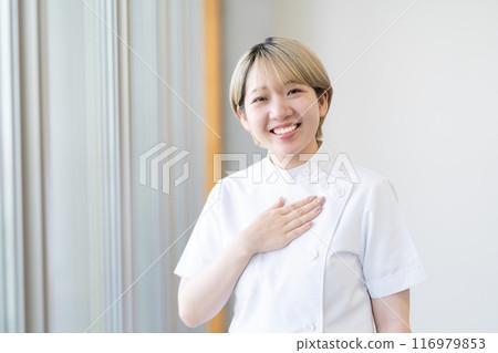 A young female chiropractor with short blonde hair wearing a Casey white coat (free hair color, work in your own way, work environment) A young female chiropractor with short blonde hair wearing a Casey white coat (free hair color, work in your own way, work environment) 116979853
