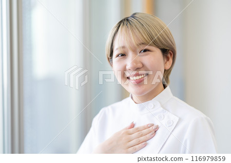 A young female chiropractor with short blonde hair wearing a Casey white coat (free hair color, work in your own way, work environment) A young female chiropractor with short blonde hair wearing a Casey white coat (free hair color, work in your own way, work environment) 116979859