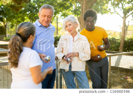 Positive diverse people joyfully looking forward to playing petanque in the park on a sunny day Positive diverse people joyfully looking forward to playing petanque in the park on a sunny day 116980396