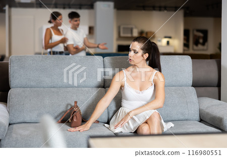 Adult woman chooses sofa in store Adult woman chooses sofa in store 116980551