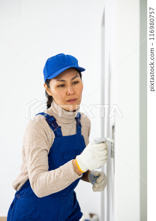 Woman applying plaster with floated trowel 116980757