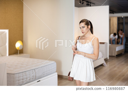 Adult woman looking around in bedroom department Adult woman looking around in bedroom department 116980887