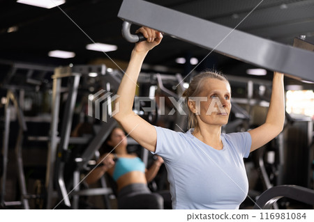 Mature woman pulls his arms to his chest on special simulator Mature woman pulls his arms to his chest on special simulator 116981084