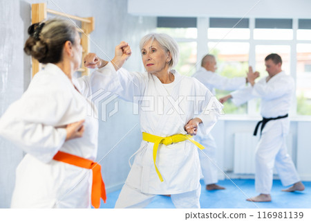 Senior karate practitioner engage in fierce fight oriental single combat 116981139