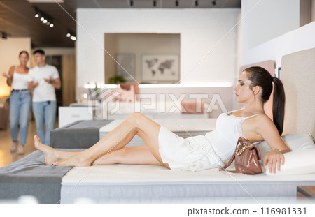 Adult woman chooses mattress in store 116981331