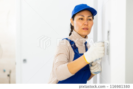 Portrait of professional female builder in process of repair at house Portrait of professional female builder in process of repair at house 116981380