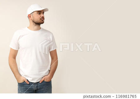 A young guy in a white T-shirt on a light background 116981765