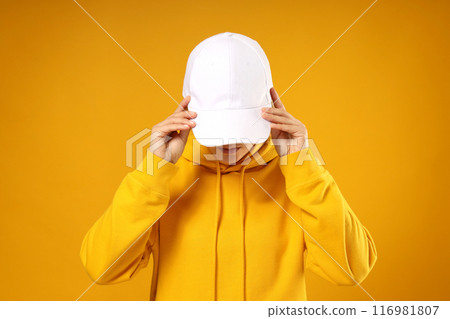 A young woman in a yellow hooded sweatshirt and cap A young woman in a yellow hooded sweatshirt and cap 116981807
