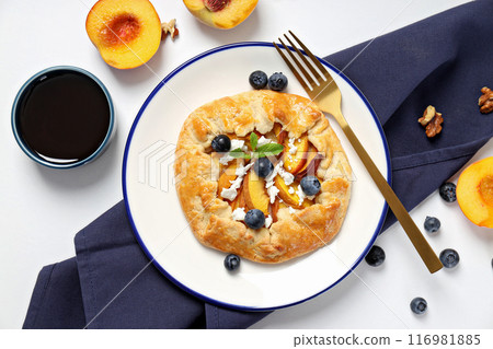Fruit galette on plate, towel, fruit and jam on white background, top view Fruit galette on plate, towel, fruit and jam on white background, top view 116981885
