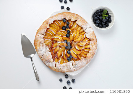 Fruit galette, scoop and berries on white background, top view 116981890