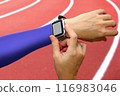 Runner setting her smart watch monitor before running on track in the stadium 116983046