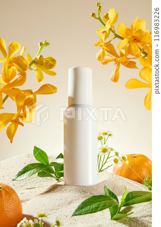 Close up shot photography in natural concept with flower, fruit and plant. An unbranded cosmetic bottle displayed on the sand, some green plants, oranges and yellow orchid on both sides 116983226