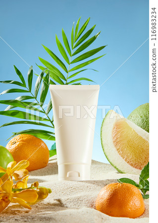 Template photo with front close up shot over the blue texture. Tropical fruits including grapefruit and orange with some yellow flowers and palm leaves surround a blank label tube in center Template photo with front close up shot over the blue texture. Tropical fruits including grapefruit and orange with some yellow flowers and palm leaves surround a blank label tube in center 116983234