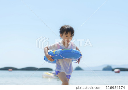 暑假期間,一個女孩在海裡游泳和玩耍 暑假期間,一個女孩在海裡游泳和玩耍 116984174