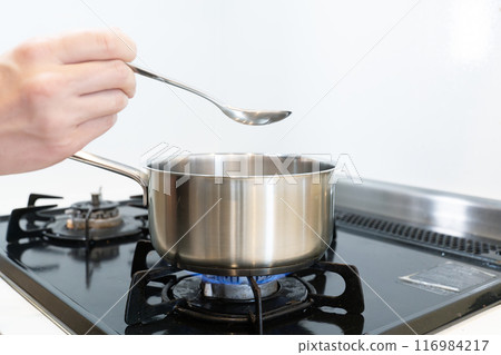 Hand pot cooking on a gas stove 116984217