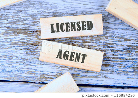Text LICENSED AGENT written on wooden blocks, a conceptual phrase against the background of old boards Text LICENSED AGENT written on wooden blocks, a conceptual phrase against the background of old boards 116984256