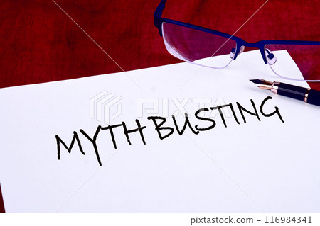 MYTH BUSTING words on white paper on a mahogany table 116984341