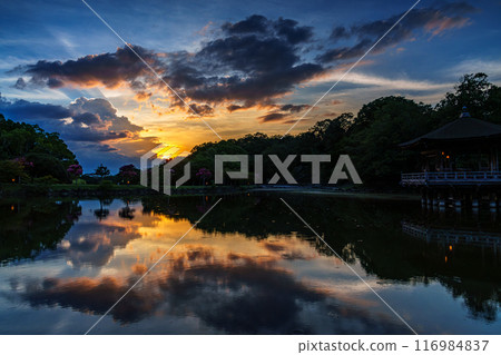 Summer 2024 Evening view of Sagiike Ukimido in Nara Park: Golden sunset dyeing the western sky and dark clouds illuminated by the setting sun① Summer 2024 Evening view of Sagiike Ukimido in Nara Park: Golden sunset dyeing the western sky and dark clouds illuminated by the setting sun① 116984837