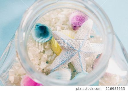 Colorful shells and starfish in a glass jar with white sand 116985633