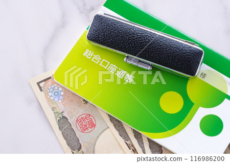 桌上放著銀行存摺、印章和 10,000 日元鈔票 桌上放著銀行存摺、印章和 10,000 日元鈔票 116986200