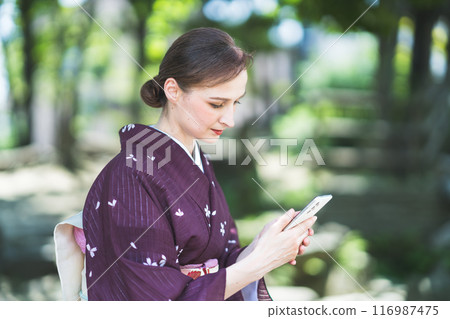 穿著和服的外國女性操作智慧型手機 穿著和服的外國女性操作智慧型手機 116987475