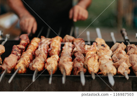 Frying shish kebab on the skewers in brazier. Fresh ruddy meat for barbecue grill on fire outdoor. Frying shish kebab on the skewers in brazier. Fresh ruddy meat for barbecue grill on fire outdoor. 116987503
