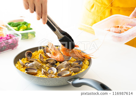 用鉗子將蝦子放在海鮮飯上。 116987614