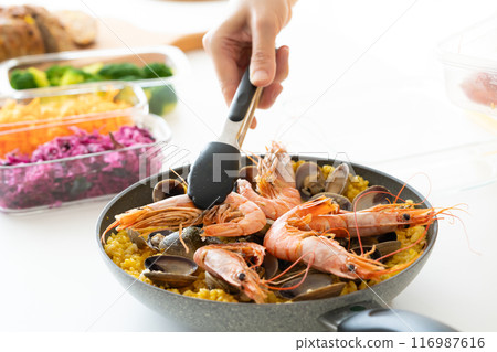 用鉗子將蝦子放在海鮮飯上。 116987616